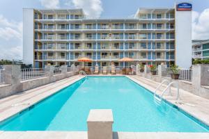 a swimming pool in front of a hotel at Howard Johnson by Wyndham Virginia Beach At The Beach in Virginia Beach