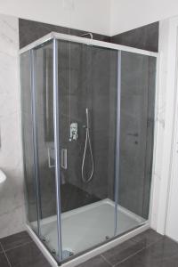 y baño con ducha y mampara de cristal. en CASA GRAMSCI B&B en Foggia