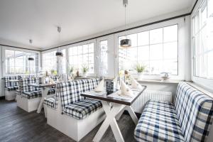 ein Restaurant mit Sofas, Tischen und Fenstern in der Unterkunft Hotel Gasthof Zur Post in Cuxhaven