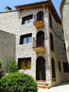 un antiguo edificio de piedra con 2 balcones. en Cal Ventura Vell, en Portell