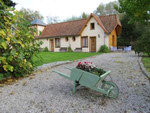 a green cart with flowers in front of a house at La Maison de l'Epousée B&B in Abbeville