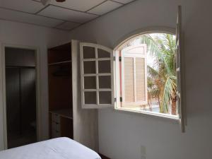 a bedroom with a window and a bed and a table at Hotel Lazer Piata in Salvador