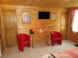 Cette chambre comprend un bureau et deux chaises rouges. dans l'établissement La Maison de l'Epousée B&B, à Abbeville