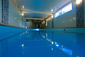a swimming pool with blue lights in a building at Tukan Hotel in Krasnaya Polyana