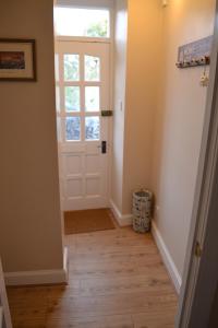 a hallway with a white door and wooden floors at Old Bridge End in Jedburgh