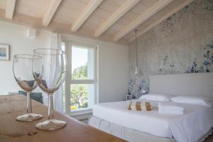 a bedroom with a bed and two wine glasses on a table at Ca Muretta Relais in Bardolino +121 photos