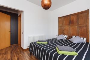 a bedroom with a black and white striped bed with two pillows at HHBCN Can Surià in Olivella