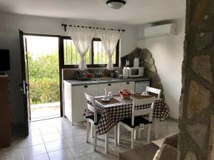 a kitchen with a table and a kitchen with a microwave at Gourgiana Apartments in Andritsaina