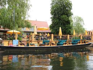 a boat with chairs and umbrellas on the water at Ferienwohnungen Pustane in Neu Zauche