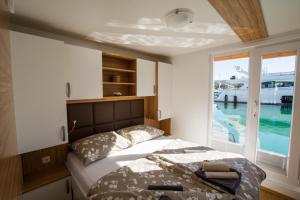 波尔托罗Floating Sea Houses MARINA LUX的带床和窗户的卧室