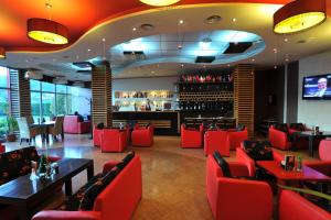 um restaurante com cadeiras vermelhas e um bar em Hotel Class em Vorë