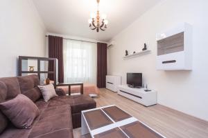 sala de estar con sofá marrón y TV en center, Apartment on Deribasovskaya 10 en Odesa