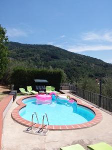 a large swimming pool with chairs and a mountain at Holiday Home Bel Panorama Due in Pelago