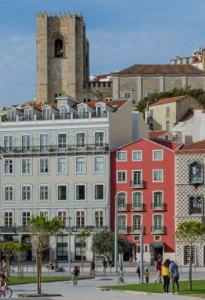 a large building with a clock tower on top of it at Hotel Riverside Alfama in Lisbon