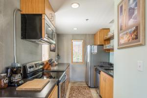 a kitchen with stainless steel appliances and wooden cabinets at The Crash Pad: An Uncommon Hostel in Chattanooga