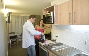a man and a woman standing in a kitchen at Focus Motel in Christchurch +17 photos
