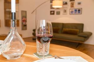 a glass of red wine sitting on a table at Apartment Joanneum in Graz