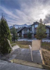 2 sedie sedute su un patio di fronte a una casa di Pinnacle Ridge Chalets by Fernie Lodging Co a Fernie