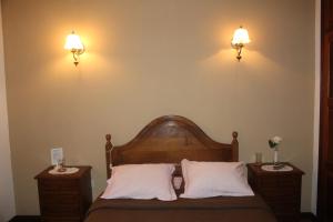 ein Schlafzimmer mit einem Bett mit zwei Nachttischen und zwei Leuchten in der Unterkunft Bem Sonhar in Terras de Bouro