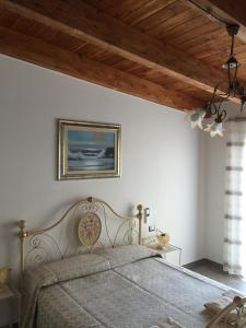 a bedroom with a bed and a painting on the wall at B&B Terre del Sinis in Càbras