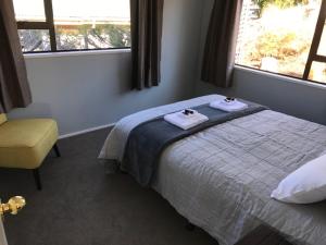 a bedroom with a bed with two towels on it at Naseby Cottage - 24 Leven St in Naseby