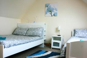a bedroom with a white bed and a blue rug at Park View in Ballachulish