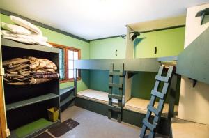 a room with two bunk beds and a ladder at HI Maligne Canyon - Hostel in Jasper