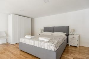 a white bedroom with a bed and a night stand at Napoli Flats in Naples