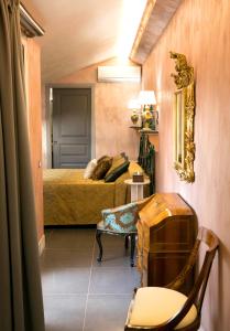 カスティリオーネ・ディ・シチーリアにあるAnimosa Suitesのベッドルーム1室(ベッド1台、テーブル、椅子付)