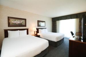 um quarto de hotel com duas camas e uma janela em Atrium Inn Vancouver em Vancouver