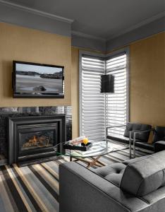 a living room filled with furniture and a fire place at Hotel Arts Kensington in Calgary