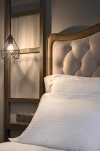 a bedroom with a bed with a headboard and a lamp at Pyrgos Hotel in Ouranoupoli