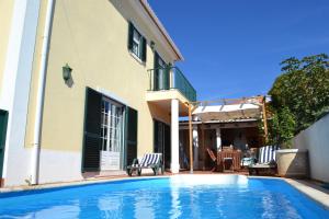 uma piscina em frente a uma casa em Yellow House Ericeira em Santo Isidoro