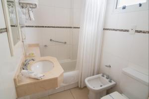 
a white toilet sitting next to a bath tub in a bathroom at Gran Hotel Continental in Mar del Plata
