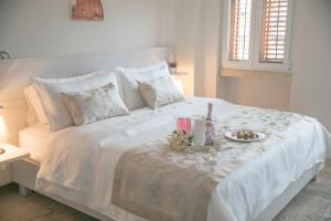 Una cama blanca con una bandeja de comida. en Hotel Boutique La Artilleria, en Cartagena de Indias