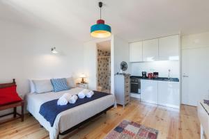 a bedroom with a bed and a small kitchen at Sunny Home in Porto