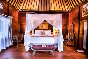 a bedroom with a bed with a canopy at Griya Valud in Sidemen