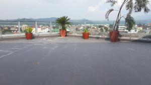 balcón con palmeras y vistas a la ciudad en YBC Grand Hotel, en Olóngapo