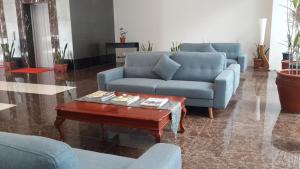 a living room with blue couches and a coffee table at YBC Grand Hotel in Olongapo