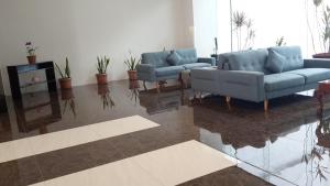 a living room with two blue couches and a table at YBC Grand Hotel in Olongapo +3 photos