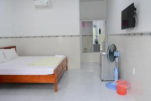 a white room with a bed and a fan at Diem Lien Guesthouse in Mui Ne