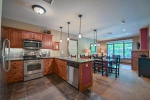 una cocina con armarios de madera y una mesa con sillas. en Silver Mountain Lodging, en Kellogg