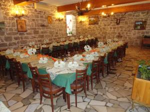 a room with a long table with green tables and chairs at Guest House Pod Slavnikom in Podgorje