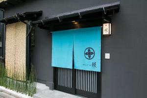 a door with a blue banner on the side of a building at Hosta Umekoji Miyabi in Kyoto
