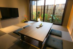 a living room with a table and a large window at Hosta Umekoji Miyabi in Kyoto