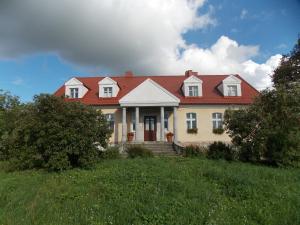 uma grande casa branca com um telhado vermelho em Dom Gościnny Ogłuszka em Pilec