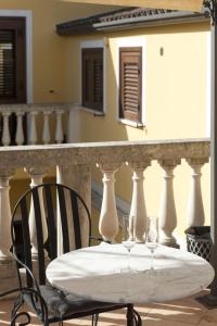 a table with two wine glasses on a balcony at B&B Sei Stelle in Sulmona