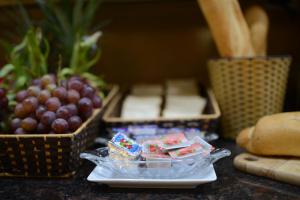 uma mesa com um prato de comida com uvas e queijo em Blue Hanoi Inn Luxury Hotel em Hanói
