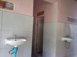 a bathroom with a sink and a mirror and a door at Sea House Guest House in Koh Rong Island