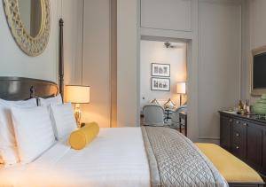 A bed or beds in a room at The Strand, Yangon